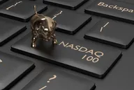 A key on a computer keyboard adapted to say NASDAQ 100, with a small gold bull charm sitting on it 