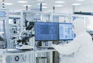 Over the shoulder view of a scientist in protective clothes in a laboratory