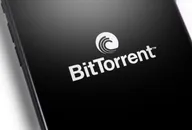 Nahaufnahme eines Smartphone-Bildschirms, der das BitTorrent-Logo vor schwarzem Hintergrund zeigt.