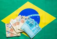 Brazilian currency on top of the national flag