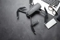 Verbraucher-Drohne auf einem Schreibtisch neben einem Laptop, die den wachsenden UAV- und Counter-Drohnen-Technologiemarkt darstellt