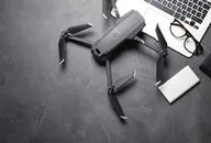 Consumer-style drone placed on a desk beside a laptop, representing the growing UAV and counter-drone technology market