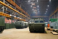 Montage von militärischen Kettenfahrzeugen in einer großen industriellen Fertigungshalle