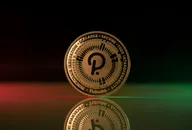 Polkadot DOT cryptocurrency physical coin placed on reflective surface and lit with green and red lights