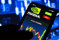 Kerzencharts, die den Nvidia-Aktienkurs zeigen, werden auf einem Mobilbildschirm mit Nvidia-Logo oben angezeigt. Im Hintergrund sind unscharfe Kerzencharts zu sehen, die auf und ab gehen.
