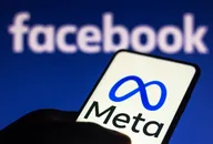 Meta logo on a mobile screen with a Facebook background