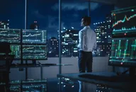 A financial trader surrounded by multiple screens