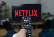 TV Television Netflix logo on screen with remote control in home.