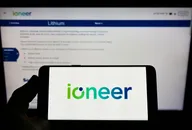 Person holding mobile phone with logo of Australian mining company company ioneer Ltd on screen in front of web page Focus on phone display