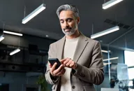 Man using a smartphone in a modern office.