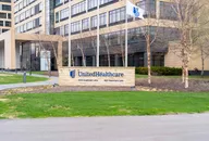 UnitedHealthcare office building exterior with company sign and flag displayed in front of the headquarters.”