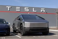 Tesla Cybertruck parcheggiato davanti a un edificio con il logo Tesla