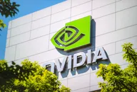NVIDIA-Logo an der Außenwand eines modernen Bürogebäudes, umgeben von grünen Bäumen.