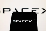 SpaceX-Logo auf einem Smartphone-Bildschirm mit verschwommenem SpaceX-Logo im Hintergrund