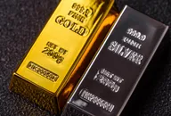 Lingotti d'oro e d'argento da investimento su sfondo scuro.
