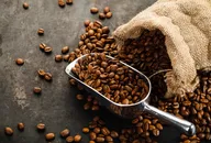 Coffee beans falling out of bag with scoop