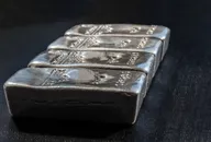 Stack of silver bullion bars arranged on a dark surface