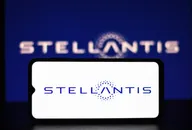Smartphone displaying the Stellantis logo against a blurred blue background