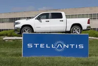 Stellantis logo on a blue sign with a white RAM pickup truck displayed above it in front of a corporate building