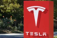 Logo Tesla affiché sur une enseigne rouge en extérieur