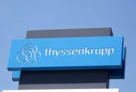 Thyssenkrupp logo on a blue sign against a clear sky