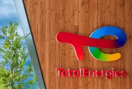 Logo TotalEnergies monté sur un mur en bois à l'extérieur d'un bâtiment