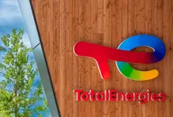 TotalEnergies logo mounted on a wooden wall outside a building