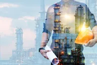 engineer in a protective helmet with a background of an oil refining plant