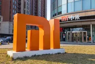 Xiaomi-Logo-Skulptur vor einem modernen Bürogebäude