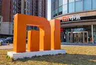 Xiaomi logo sculpture in front of a modern office building