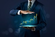 S&P 500 vs US Tech 100: Recession outlook The concept of business growth, progress or success. A businessman shows a growing stock of a virtual hologram on a dark background.