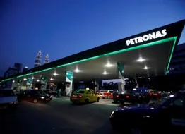 A file photo of motorists queuing to fill natural gas at a Petronas station with its landmark Petronas Twin Towers headquarters in the background, in Kuala Lumpur February 4, 2012.