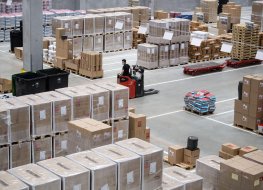 Employee drives a forklift truck in a warehouse