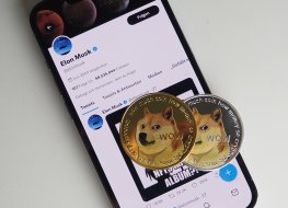 Dogecoins rest on a smartphone displaying Twitter