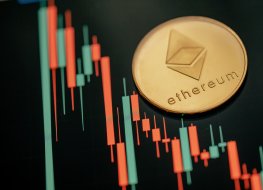 A gold Ethereum coin on a price chart