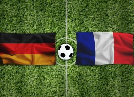 Germany and France flags and ball on football pitch 