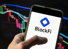  In this photo illustration the Blockfi logo seen displayed on a smartphone with an economic stock exchange index graph in the background
