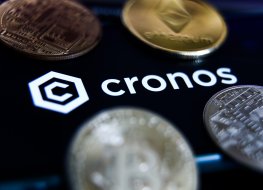Cronos logo displayed on a phone screen and representation of cryptocurrencies are seen in this illustration photo taken in Krakow, Poland