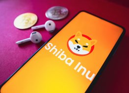 In this photo illustration, the Shiba Inu (SHIB) logo seen displayed on a smartphone screen, next to two cryptocurrencies and headphones