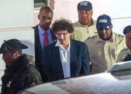  FTX founder Sam Bankman-Fried (C) is led away handcuffed by officers of the Royal Bahamas Police Force in Nassau, Bahamas on 13 December, 2022