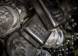 Silver coins and bullion on a dark background