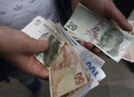 A customer counts Turkish lira bank notes
