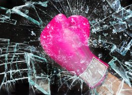 Photo of pink boxing glove breaking glass