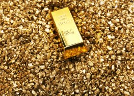 A block of gold on a bed of gold nuggets 