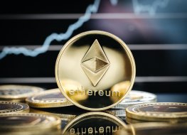 An Ethereum gold coin in front of a price chart