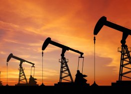 Oil pump rigs set against a sunset sky