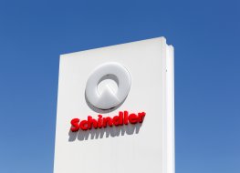 The white and red Schindler logo seen on a sign