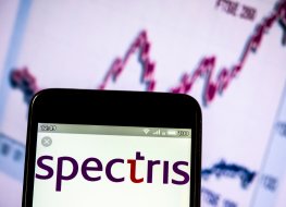 Spectris logo on a smartphone against a graph