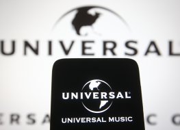 Universal Music Group B.V. (UMG) logo of a global music corporation is seen on a mobile phone and a computer screen