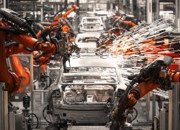 Robots add parts along a car assembly production line 